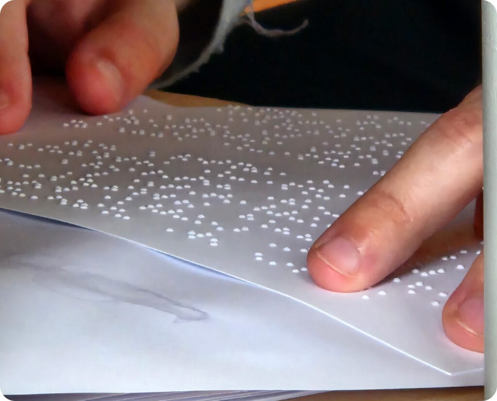 Degete citind o partitură în Braille